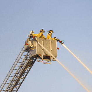 Firefighters Spraying Water from Ladder